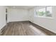 Open living room with hardwood floors, a large window, and entry door at 4337 N Audubon Rd, Indianapolis, IN 46226