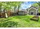 The backyard features a playground, garden beds, and a light green house and garage at 4447 N College Ave, Indianapolis, IN 46205