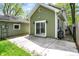An exterior view of a light green house with a concrete patio and sliding door to the backyard at 4447 N College Ave, Indianapolis, IN 46205