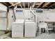 A laundry area with a washer, dryer, wash sink and concrete floor in the basement at 4447 N College Ave, Indianapolis, IN 46205