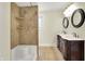 Bathroom featuring a double vanity, a walk-in shower, and neutral tiling for a modern aesthetic at 4447 N College Ave, Indianapolis, IN 46205