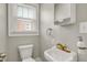 Charming bathroom featuring a sink with gold fixtures and a window with natural light at 4447 N College Ave, Indianapolis, IN 46205