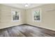 Well-lit bedroom with neutral walls, new flooring, ceiling fan and two windows offering pleasant natural light at 4447 N College Ave, Indianapolis, IN 46205