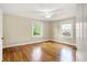 Bright bedroom with hardwood floors, trim, a ceiling fan, and two large windows offer ample natural light at 4447 N College Ave, Indianapolis, IN 46205