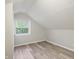 Bedroom featuring light gray walls, wood-look floors, and natural light streaming through the window at 4447 N College Ave, Indianapolis, IN 46205