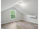Bright bedroom featuring light gray walls, wood-look floors, and an air conditioning unit at 4447 N College Ave, Indianapolis, IN 46205
