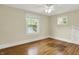 A bright bedroom with light walls, trim, a ceiling fan and light colored wood floors at 4447 N College Ave, Indianapolis, IN 46205