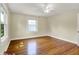 Bedroom features gleaming hardwood floors, neutral walls, and a large window overlooking the front yard at 4447 N College Ave, Indianapolis, IN 46205