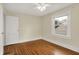An inviting bedroom features hardwood floors, light colored walls and trim, and a window at 4447 N College Ave, Indianapolis, IN 46205
