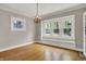 Dining area featuring hardwood floors, a chandelier, and natural light from three large windows at 4447 N College Ave, Indianapolis, IN 46205