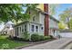 Charming two-story home with a red brick chimney, screened-in porch, lush yard, and detached two-car garage at 4447 N College Ave, Indianapolis, IN 46205