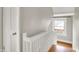 A view of the upstairs hallway with hardwood stairs and white railing at 4447 N College Ave, Indianapolis, IN 46205