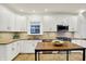 Well-lit kitchen with stainless appliances and a wood topped table with metal legs at 4447 N College Ave, Indianapolis, IN 46205