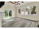 Bright living room featuring vaulted ceilings, many windows, a ceiling fan, and sliding glass doors to backyard at 4447 N College Ave, Indianapolis, IN 46205