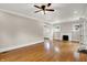 Spacious living room featuring hardwood floors, a ceiling fan, fireplace, and ample natural light at 4447 N College Ave, Indianapolis, IN 46205
