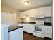 Well-lit kitchen with white cabinets, dark countertops, and stainless-steel appliances at 4527 Peachwood Ct, Indianapolis, IN 46235