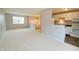 Bright living room featuring neutral walls, carpet, and views to the staircase and kitchen at 4527 Peachwood Ct, Indianapolis, IN 46235