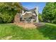 Multi-level wooden deck with seating, fire pit, and large shade umbrella in a lush green backyard at 4601 Fairhope Dr, Indianapolis, IN 46237