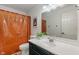 Bathroom with modern fixtures, black vanity, shower with orange curtain, and a framed picture at 4601 Fairhope Dr, Indianapolis, IN 46237