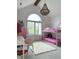 Bright bedroom features a vaulted ceiling, large window, stylish chandelier and a modern bunk bed with pink linens at 4601 Fairhope Dr, Indianapolis, IN 46237