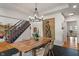 Charming dining room featuring a wooden table, chandelier, and stairs with patterned carpet at 4601 Fairhope Dr, Indianapolis, IN 46237