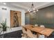 Dining room with a large painting, wooden table, black floors, and modern chandelier at 4601 Fairhope Dr, Indianapolis, IN 46237
