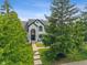 Striking front exterior view of a white house with black trim, manicured lawn and mature trees at 4601 Fairhope Dr, Indianapolis, IN 46237