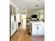 Bright kitchen with hardwood floors and white cabinets leading to a living area, great for modern living at 4601 Fairhope Dr, Indianapolis, IN 46237