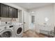 Laundry room features modern washer/dryer, wash basin, and views into the next room at 4601 Fairhope Dr, Indianapolis, IN 46237