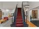 Grand staircase featuring a red carpet runner, elegant black banisters, and access to multiple living spaces at 4601 Fairhope Dr, Indianapolis, IN 46237