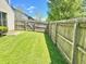 Backyard with a grassy lawn, bordered by a tall wooden fence, enhancing privacy and providing ample space at 4947 Peony Pl, Indianapolis, IN 46254