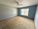 A carpeted bedroom featuring a window and ceiling fan at 4947 Peony Pl, Indianapolis, IN 46254