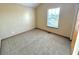 A bright, carpeted bedroom with a window at 4947 Peony Pl, Indianapolis, IN 46254