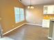Cozy dining area featuring vinyl floors, a window with blinds, and adjacent to the kitchen area at 4947 Peony Pl, Indianapolis, IN 46254
