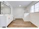 This updated bathroom has modern fixtures and finishes, plus a walk-in shower and wood-look flooring at 4956 W 11Th St, Speedway, IN 46224
