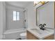 Well-lit bathroom with a modern vanity, elegant mirror, and subway-tiled shower-tub combination at 4956 W 11Th St, Speedway, IN 46224