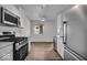 Modern kitchen with stainless steel appliances, white cabinets, and hardwood floors at 4956 W 11Th St, Speedway, IN 46224