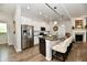 Open-concept kitchen with stainless steel appliances, a large island, and stylish pendant lighting at 5755 Buskirk Dr, Indianapolis, IN 46216
