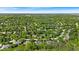 An aerial shot reveals a neighborhood with tree-lined streets, green yards, and various home styles on a sunny day at 5783 Coopers Hawk Dr, Carmel, IN 46033