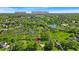 An aerial view highlights a community near Northview Church and Aletto Gathering Sports Center with lush greenery and a tranquil pond at 5783 Coopers Hawk Dr, Carmel, IN 46033