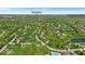A beautiful aerial view near Conner Prairie and Plum Creek Country Club showcases community homes, a pond, and green spaces at 5783 Coopers Hawk Dr, Carmel, IN 46033