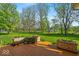 Backyard deck with planters overlooking a sprawling grassy yard and mature trees at 5783 Coopers Hawk Dr, Carmel, IN 46033