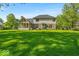 Backyard view of home with large grassy yard and screened-in porch at 5783 Coopers Hawk Dr, Carmel, IN 46033