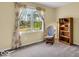 Cozy room with a rocking chair, bookshelf, and floral curtains framing a bright window at 5783 Coopers Hawk Dr, Carmel, IN 46033