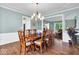 Dining room features a wooden table set with seating for six, illuminated by a chandelier, perfect for meals at 5783 Coopers Hawk Dr, Carmel, IN 46033