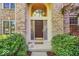 Elegant front entrance with a decorative door, sidelights, and manicured landscaping at 5783 Coopers Hawk Dr, Carmel, IN 46033