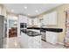 Charming kitchen with stainless appliances, white cabinetry, tile floor, and a granite countertop island at 5783 Coopers Hawk Dr, Carmel, IN 46033