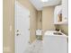 Bright laundry room with a utility sink, white cabinets, and a modern washer at 5783 Coopers Hawk Dr, Carmel, IN 46033