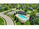Aerial view of a community pool featuring lounge chairs, a pergola, and lush green landscaping in a neighborhood at 5783 Coopers Hawk Dr, Carmel, IN 46033
