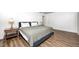 Bright bedroom features wood-look flooring, a queen bed with soft linens and modern decor at 6005 Apache Dr, Indianapolis, IN 46254